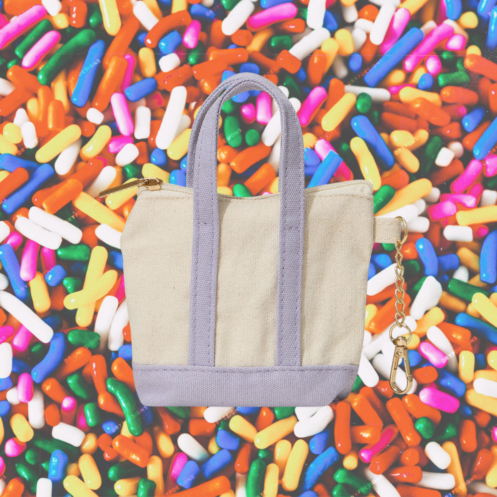 Beige tote bag with lavender handles on a colorful sprinkles background