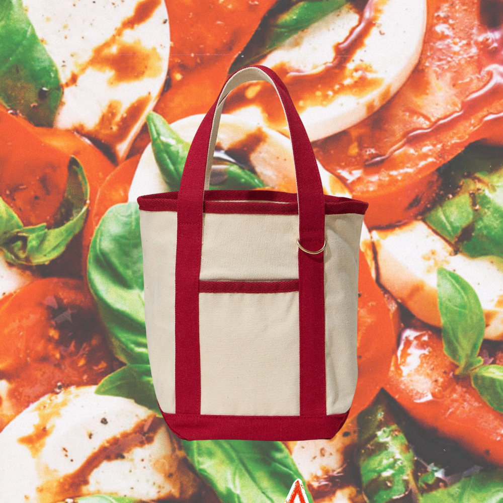 White tote bag with red handles on a pizza background